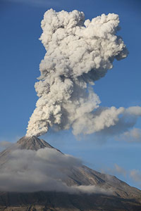 Ash cloud from Colima volcano rising into blue sky