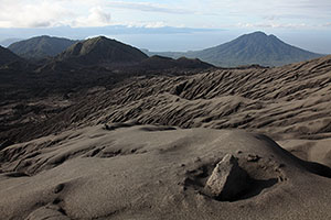 Gunung Mamuya viewed from Dukono volcano. Volcanic bomb in foreground
