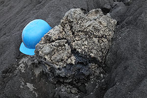 Fresh lava bomb with helmet for scale, Dukono volcano
