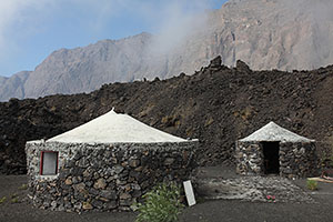 Traditional farm dwellings with lava flow behind, Fogo Caldera
