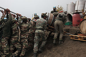 Soldiers placing wine barrel on hillside terrace, Evacuation of Portela, Fogo Eruption 2014