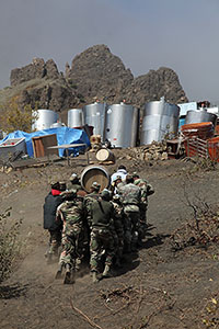 Soldiers carrying wine barrels up hill, Portela, Fogo Volcano Eruption, 2014