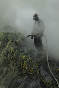 Kawah Ijen volcano, sulfur mine. Miner with hose.