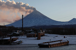 Kliuchevskoi volcano erupting ash. Kliuchi settlement and Kamchatka River in foreground