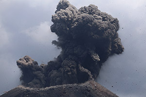 Ash and volcanic bombs being ejected by Anak Krakatau volcano