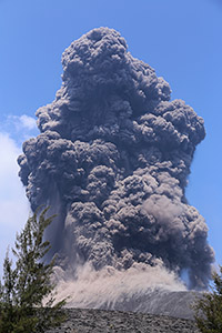 Ash cloud rising from Anak Krakatau with bombs landing on flank