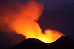 Nyamuragira Volcano lava in cone illuminating gas cloud during blue hour