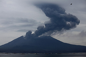 Ash cloud from Sakurajima volcano rising into weather clouds