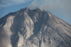 Building with Sinabung volcano behind