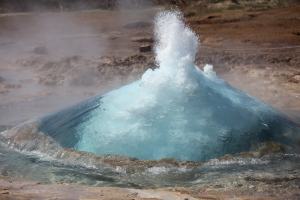 Jet of steam breaks through surface of water bubble or dome of Strokkur Geysir Geyser